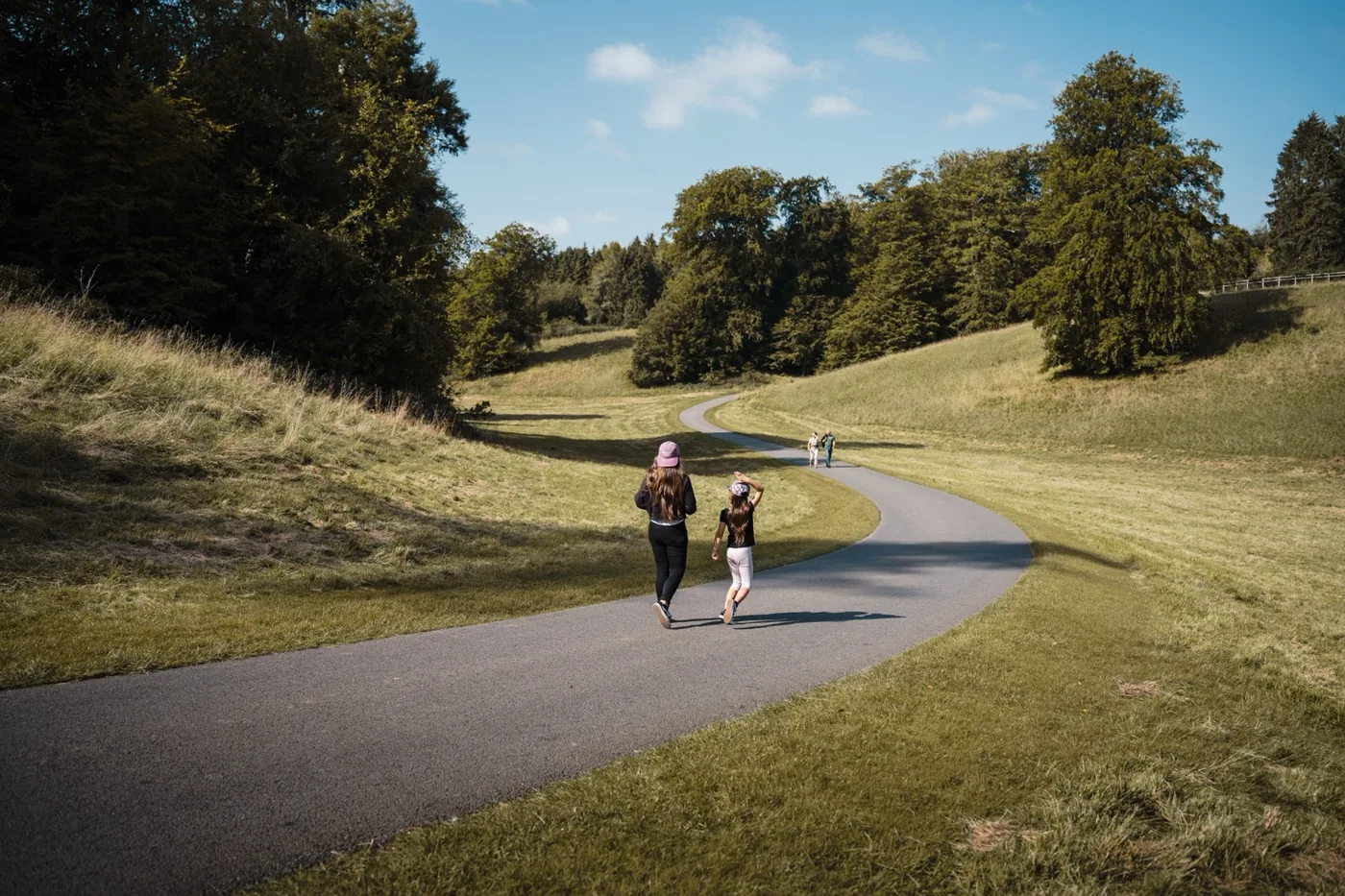Family walking along a path through open parkland